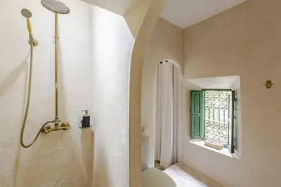 a bathroom with a shower and a toilet and a window at Riad Privé Dar Yaël in Marrakech