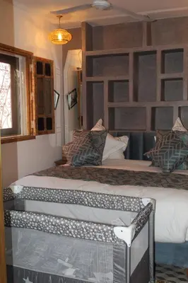a bedroom with two beds and a window at RIAD LUXE LOCATION le GRIZZLY in Marrakech