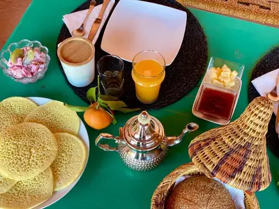 a green table with a teapot and a plate of food at Riad Dar Balthazar in Marrakech