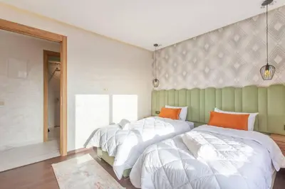 two beds sitting next to each other in a bedroom at Design, résidence standing, Salon modern, Terrasse in Marrakech