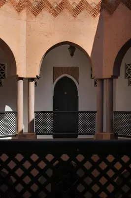 a building with arches and a black door at Villa Al Assala Palmeraie in Marrakech
