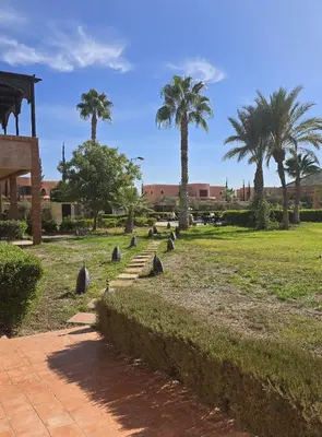 a park with palm trees and a path at Riad Mhidou Marrakech in Marrakech