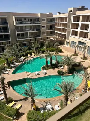 an overhead view of a large swimming pool with palm trees at Garden Marrakech Luxury in Marrakech