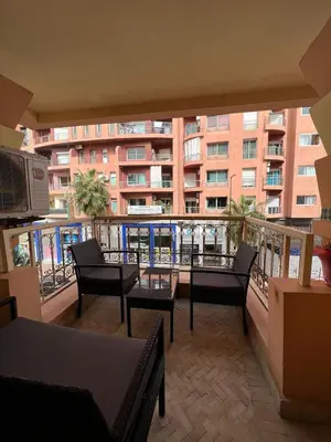 a balcony with chairs and tables and a building at 1 Bed Flat - Sleeps 2 - Parking - Wifi in Marrakech