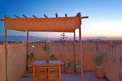 a wooden structure with birds sitting on top of a fence at Oasis appart sérénité in Marrakech