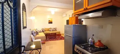 a kitchen with a refrigerator and a living room at Studio l'Oasis de la Palmeraie in Marrakech