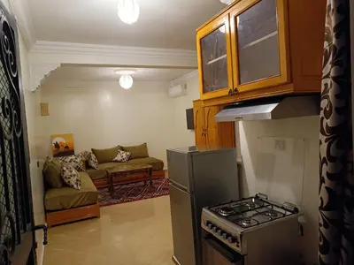 a kitchen with a stove and a couch in a room at Studio l'Oasis de la Palmeraie in Marrakech