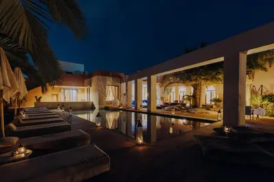 a villa with a swimming pool at night at Les Jardins de Kesali By La Siredrah in Marrakech