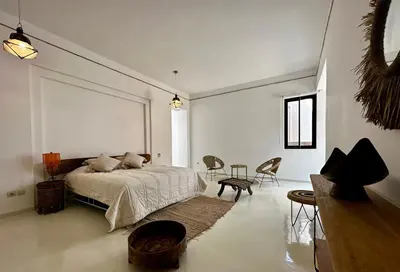 a bedroom with a bed and a table and chairs at Les Jardins de Kesali By La Siredrah in Marrakech