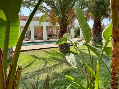 a yard with palm trees and a swimming pool at Les Jardins de Kesali By La Siredrah in Marrakech