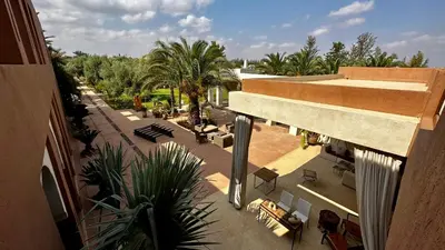 an overhead view of a building with a courtyard with palm trees at Les Jardins de Kesali By La Siredrah in Marrakech