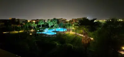a view of a swimming pool at night with lights at Marrakech Prestigia appartement vue piscine golf endroit calme in Marrakech