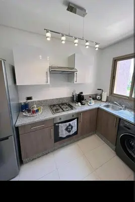 a kitchen with a sink and a stove at Marrakech Prestigia appartement vue piscine golf endroit calme in Marrakech