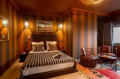 a bedroom with a bed and a chair in it at LES TANNEURS PENTHOUSE MARRAKECH in Marrakech