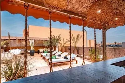 a patio with chairs and tables on a roof at LES TANNEURS PENTHOUSE MARRAKECH in Marrakech
