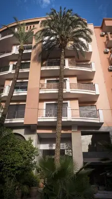 two palm trees in front of a building at Résidence Las Palmeras in Marrakech