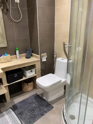 a bathroom with a white toilet and a shower at Résidence Las Palmeras in Marrakech