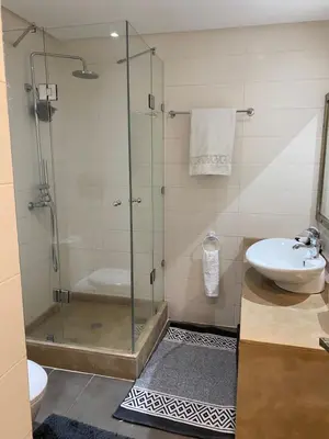 a bathroom with a glass shower and a sink at Résidence Las Palmeras in Marrakech