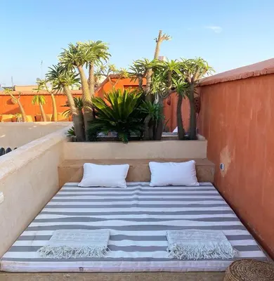 a mattress sitting on a balcony with palm trees at Riad Rossi in Marrakech