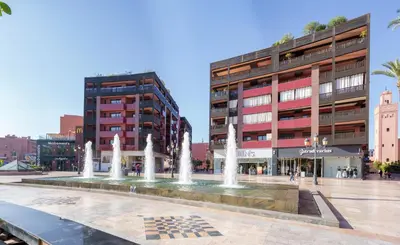 a fountain in a square in front of a building at Appartement Chic Gueliz Plaza avec Vue in Marrakech