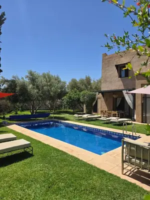 a swimming pool in the yard of a house at Villa Ily Marrakech Oasis privée avec piscine chauffée et panorama Atlas in Marrakech