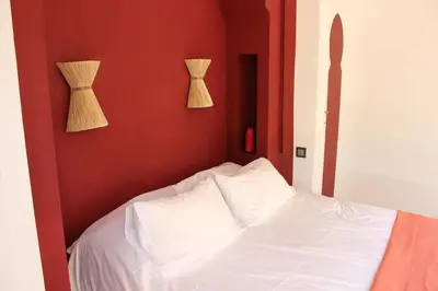 a bedroom with a white bed and two vases on the wall at Villa Ily Marrakech Oasis privée avec piscine chauffée et panorama Atlas in Marrakech