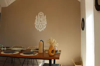 a dining room table with a chandelier on the wall at Villa Ily Marrakech Oasis privée avec piscine chauffée et panorama Atlas in Marrakech