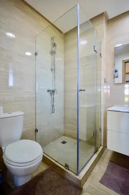 a bathroom with a toilet and a glass shower at Appartement, Prestigia Marrakech in Marrakech