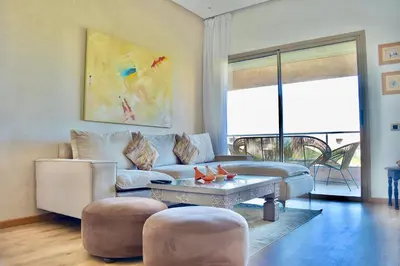 a living room with a couch and a table at Appartement, Prestigia Marrakech in Marrakech