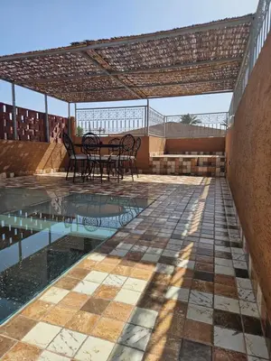 a patio with a table and chairs next to a pool at Riad Latifa in Marrakech