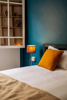 a bed with a yellow pillow and a blue wall at Cosy Appartement 5min de Majorelle in Marrakech