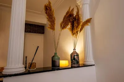 two vases with feathers in them sitting on a shelf at Cosy Appartement 5min de Majorelle in Marrakech