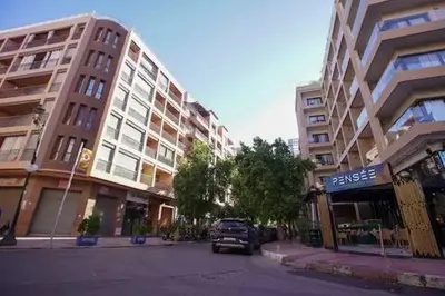 a street in a city with tall buildings and a car at Charming Cozy 2 Bedrooms central Gueliz in Marrakech