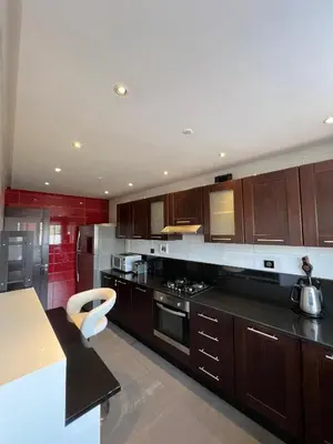 a kitchen with wooden cabinets and a stove top oven at GUELIZ, majorelle, Beautiful apartment with large terrace in Marrakech