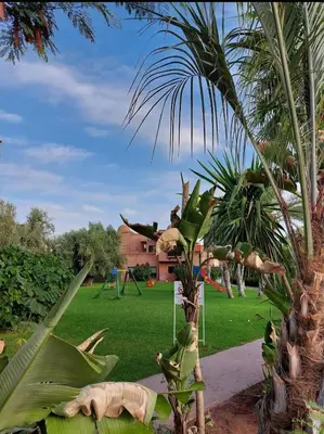 a park with a palm tree and a playground at Atlas golf resort in Marrakech